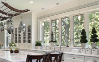 a large kitchen with white cabinets and marble counter tops