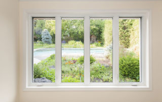 four windows with a view of a green yard