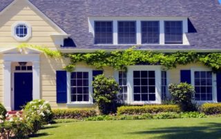 a yellow house with blue shutters and windows