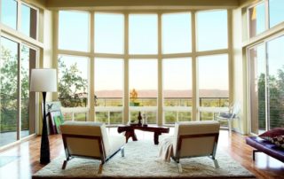 A living area with large casement windows filling the walls