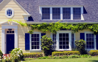 a yellow house with blue shutters and windows