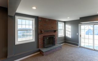 an empty living room with a brick fireplace