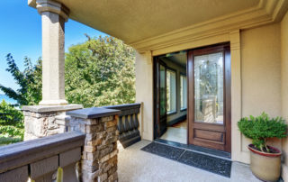 a balcony with a potted plant and door