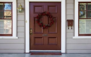 the front door of a house with shutters and a wreath